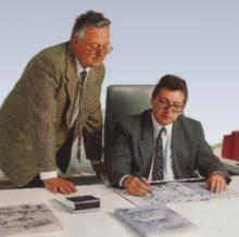 Klaus und | Hans Peter Traub Auf dem Foto sind die beiden damaligen Senior-Chefs Klaus und Hans Peter Traub zu sehen, wie sie gemeinsam über einem Bauprojekt beraten.